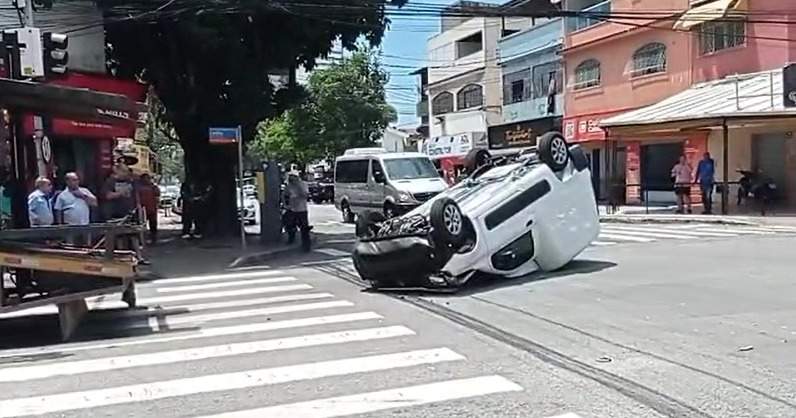 Carro fica destruído após cair de caminhão-cegonha que entalou em